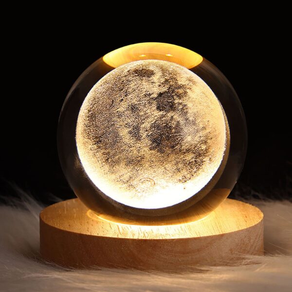 Crystal ball night light with 3D moon interior carving, emitting a soft warm glow, perfect for a dreamy and magical ambiance.