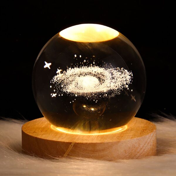 Crystal ball night light with 3D galaxy interior carving, emitting a soft warm glow, perfect for a dreamy and magical ambiance.
